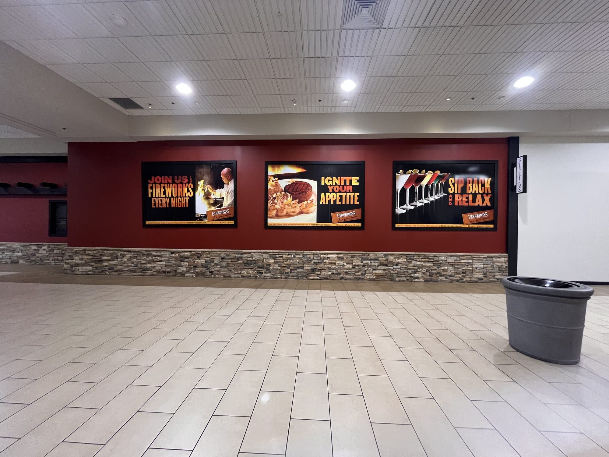 Three-panel Firebirds promotional wall installation in a mall corridor