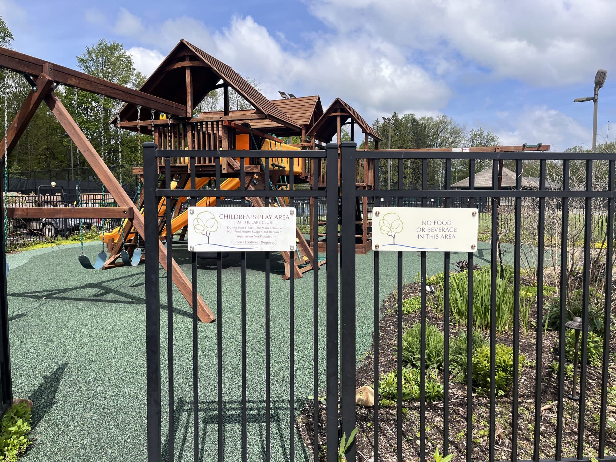 Wider view of the children's pool area with branded entry signage and play structure