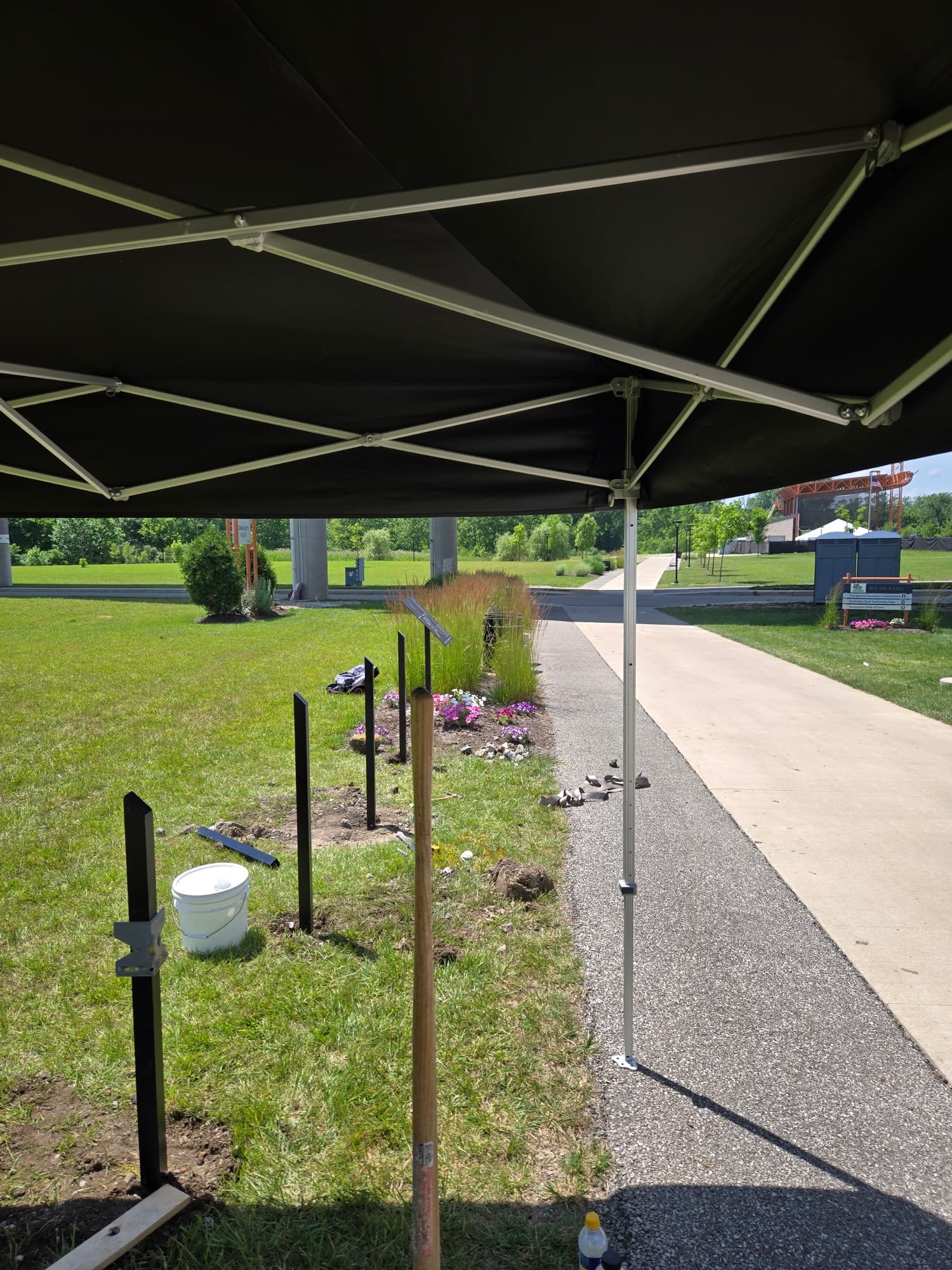Install in progress under a work canopy with empty plaque posts in line